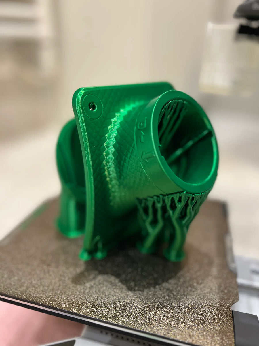 Grüner 3D-gedruckter Prototyp eines Zyklon-Einlasses mit Baumstützen auf dem Druckbett