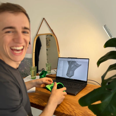Adrian von Die Tüftlerei am Schreibtisch mit CAD-Konstruktion am Laptop und 3D-gedrucktem Zyklon-Einlass-Prototyp