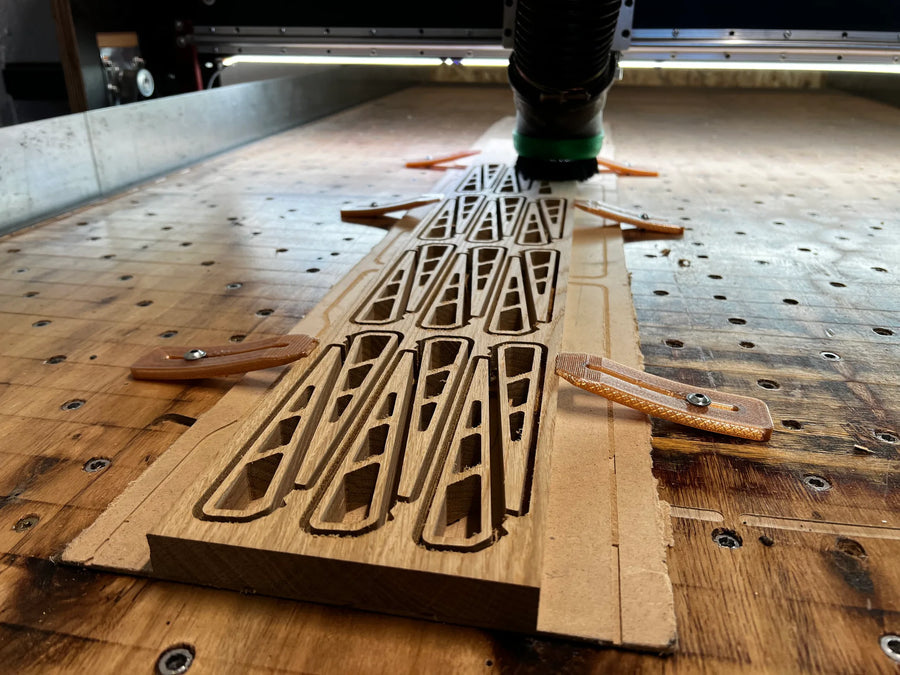 CNC-Fräsen von Ausschnitten in einer Massivholzplatte aus Eiche, fixiert mit Spannpratzen